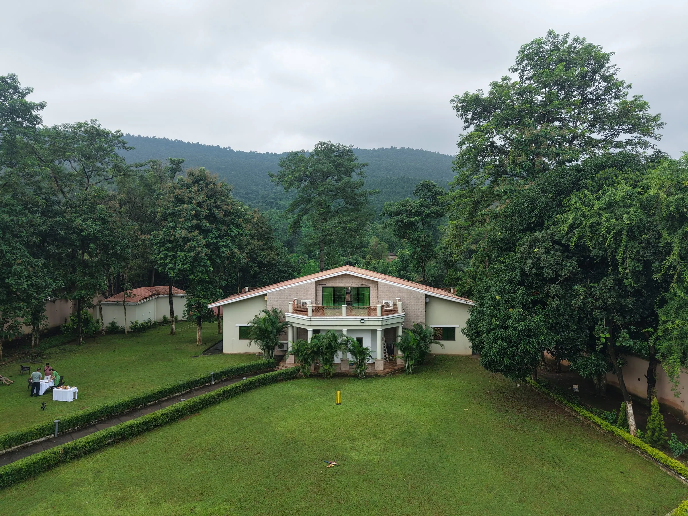 The Nature's Nest farmhouse set against forested hills near Jamshedpur